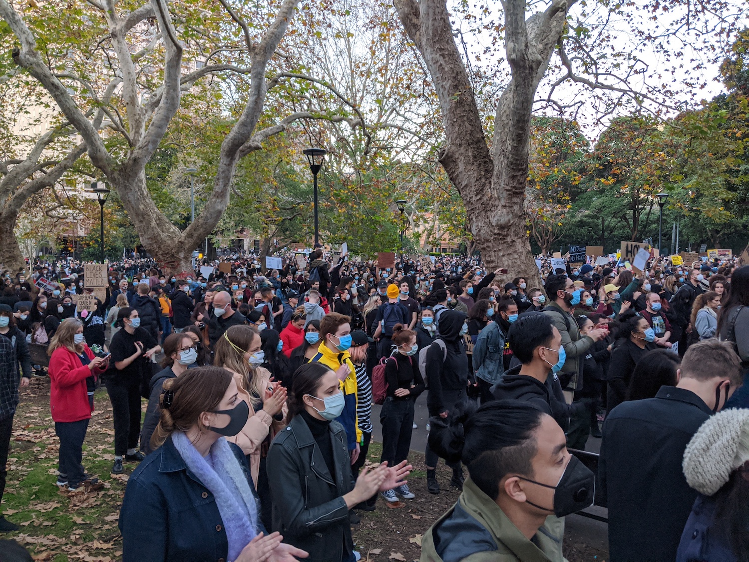 Protesters listening and clapping for the vigil at the end of the march